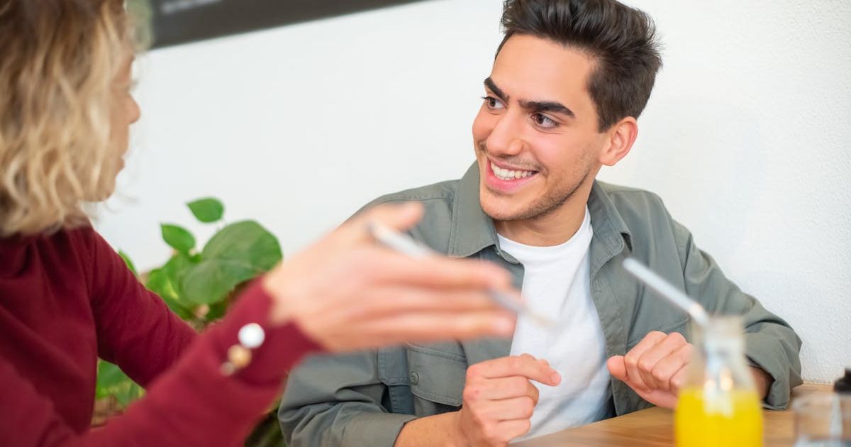 Two people practicing conversational Spanish at a cozy cafe | Audaz Revista