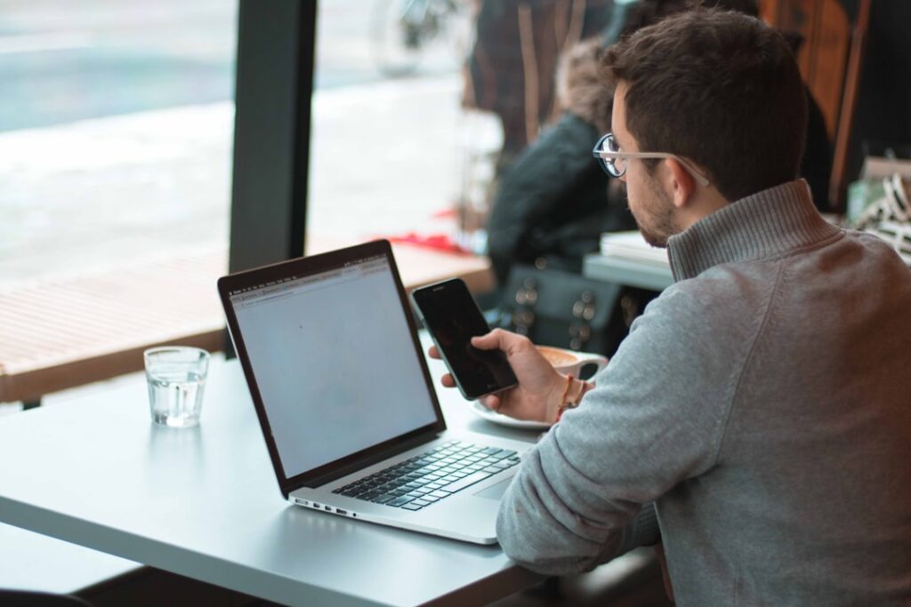 A person practising Spanish on a laptop and phone using a language-learning app