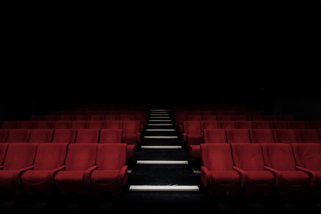 Rows of red cinema seats facing a screen