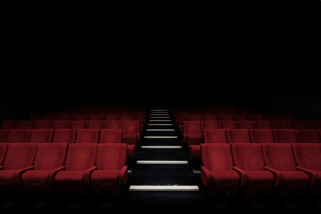Rows of red cinema seats facing a screen