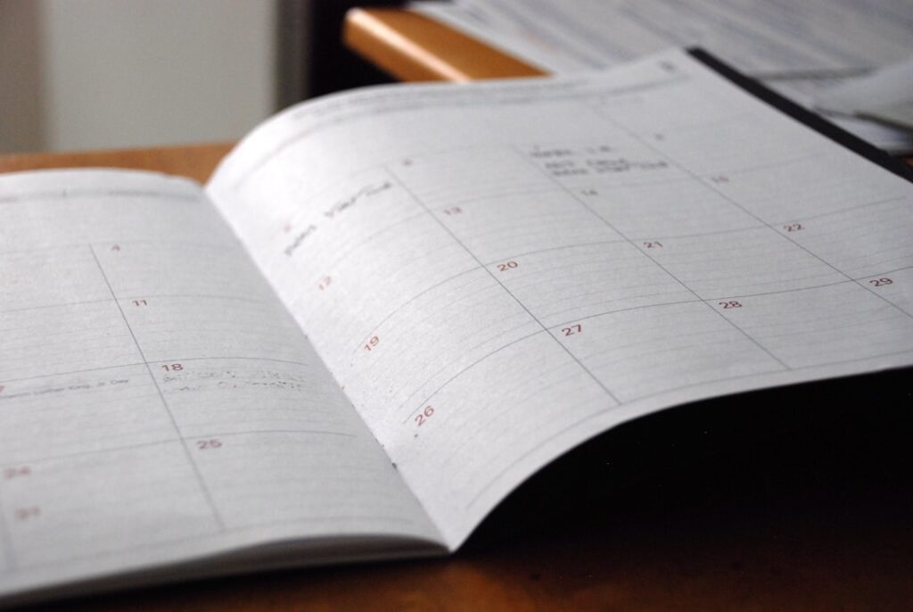 A paper calendar and notebook on a desk, for planning the future in Spanish