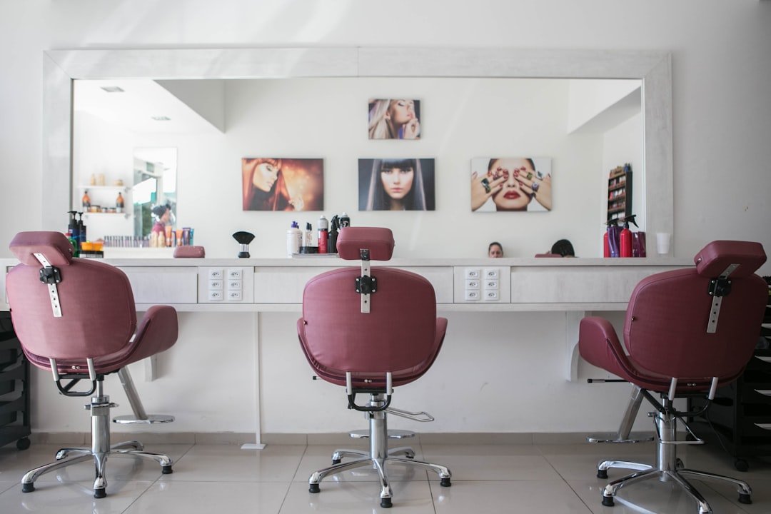 A hairdresser cutting a client's hair in a salon chair
