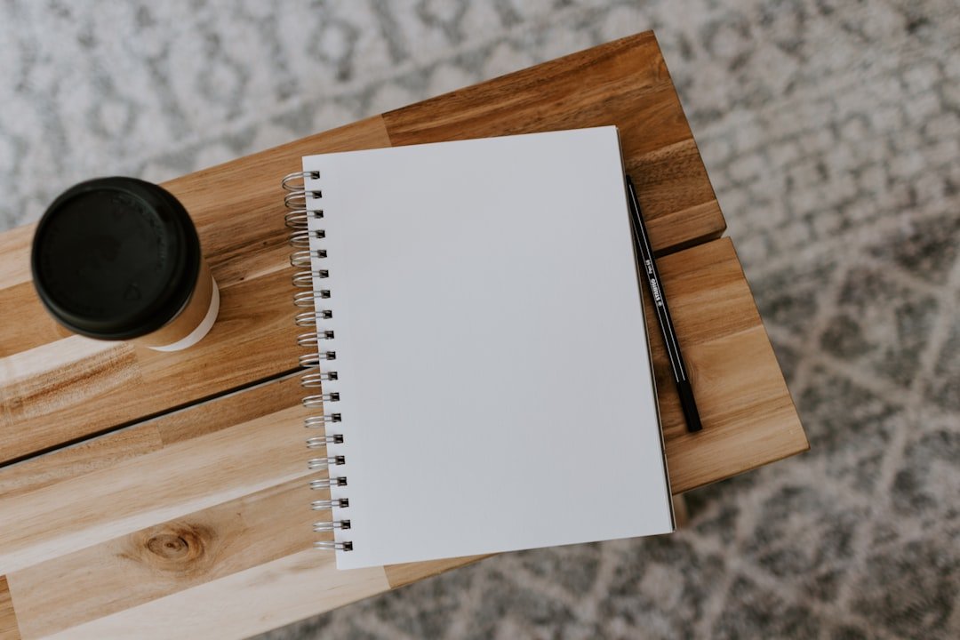 An open notebook and pen beside a coffee, the setup for daily Spanish vocabulary practice alongside the ten verified Spanish Instagram accounts reviewed in this guide.